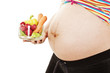 Photo: The young pregnant woman with vegetables on a white background The young pregnant woman with vegetables on a white background
