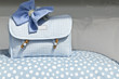 Porta accessori celeste su copriletto a pois