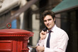 A businessman posting letters in a letterbox