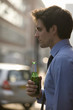 A businessman holding a bottle of beer