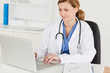 Photo: Attractive female doctor working on her laptop Attractive female doctor working on her laptop