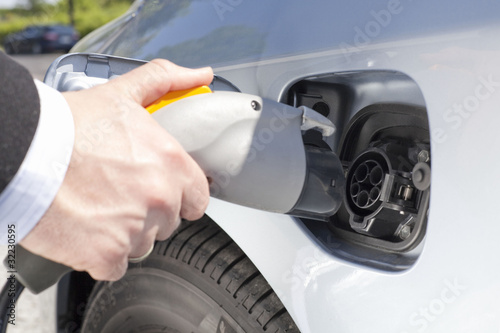 Photo: Tankstutzen und Zapfpistole bei einem Elektroauto Tankstutzen und Zapfpistole bei einem Elektroauto