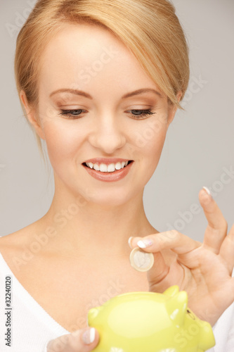 Photo: lovely woman with piggy bank and money lovely woman with piggy bank and money