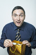 Surprised young man in tie opening packet with a present