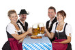 Bayrische Mädchen und Männer trinken Oktoberfest Maß Bier