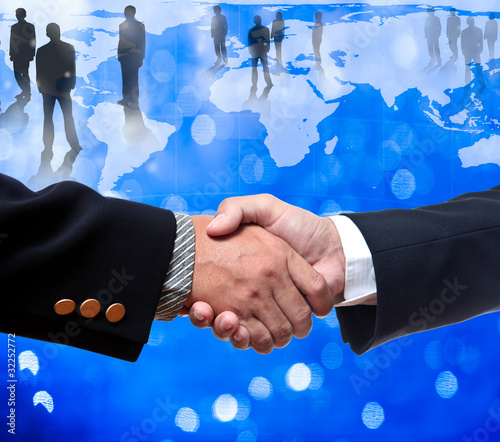 Photo: Shake hands with bussiness people standing on the globe Shake hands with bussiness people standing on the globe