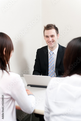 Photo: a young businessman talking to women a young businessman talking to women