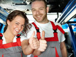 Foto: Happy apprentices in a garage are proud and show thumbs up Happy apprentices in a garage are proud and show thumbs up