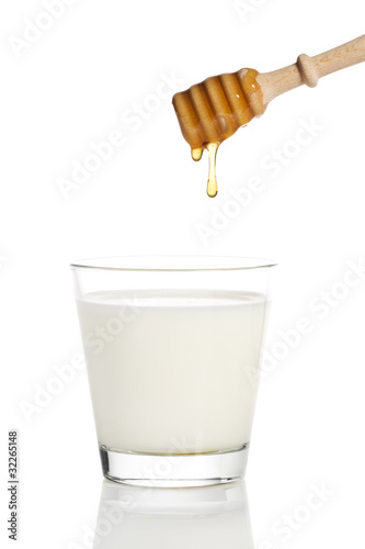 Photo: honig tropft von einem honiglöffel in ein glas milch honig tropft von einem honiglöffel in ein glas milch