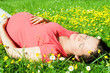 Beautiful pregnant woman laying on grass Beautiful pregnant woman laying on grass