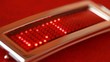 gold led buckle with running line PROJECT on red background