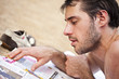 homme lit un magazine sur la plage en vacances