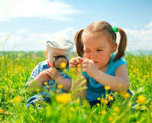 Photo: Children are playing on green meadow Children are playing on green meadow