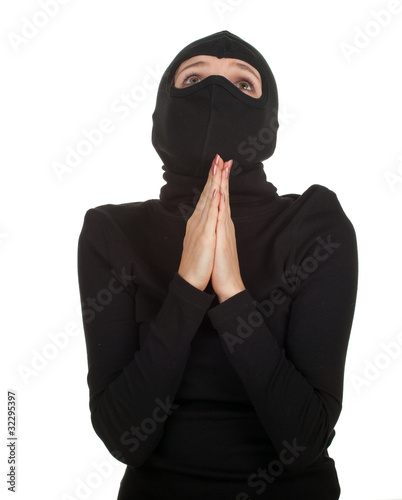 Photo: praying female thief in black clothes and balaclava praying female thief in black clothes and balaclava