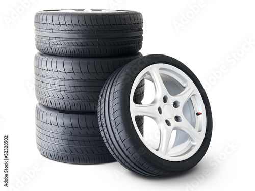 Foto: Isolated set of low profile summer tyres with one wheel in front Isolated set of low profile summer tyres with one wheel in front