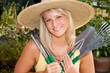 Junge Frau mit Gartenwerkzeugen