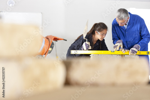 Photo: Teacher talking to student using level in bricklaying vocational school Teacher talking to student using level in bricklaying vocational school