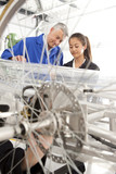 Photo: Teacher helping students constructing electric vehicle prototype in vocational school Teacher helping students constructing electric vehicle prototype in vocational school