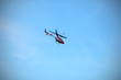 Photo: Radio controlled helicopter flying against blue sky. Radio controlled helicopter flying against blue sky.