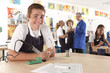 Smiling student using soldering iron in vocational school