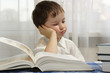 Boy is bored near the book