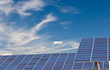 Photovoltaic panels over a deep blue sky.