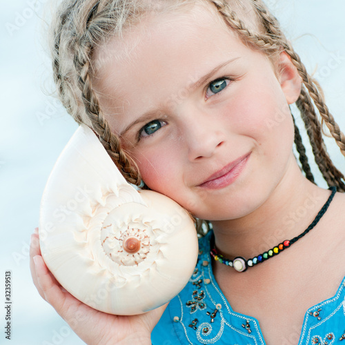 Photo: Girl with shell at the beach Girl with shell at the beach