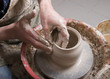 The hands of a potter, creating an earthen jar on the circle