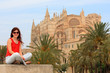Young woman sitting in front of La Seu Cathedral in Majorca