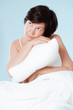 Thinking woman embracing her pillow