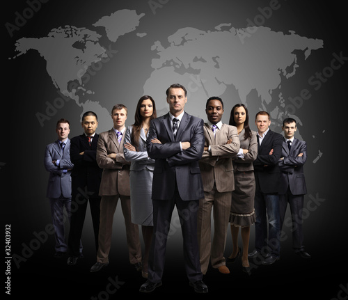Photo: Businessmen standing in front of an earth map Businessmen standing in front of an earth map