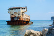 Rusty sunken ship among the sea rocks