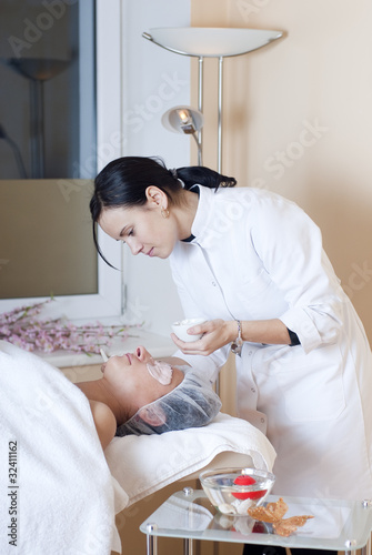 Photo: Beautician applying facial mask Beautician applying facial mask