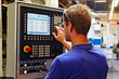 skilled worker controlling a digitally programmed machine tool