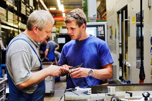 Photo: skilled workers controlling a workpiece skilled workers controlling a workpiece