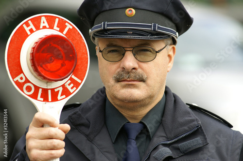 Foto: Polizist mit Polizeikelle Polizist mit Polizeikelle