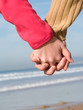 Lovers couple holding hands on beach at winter Lovers couple holding hands on beach at winter