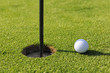 Golf ball near hole on golf course Golf ball near hole on golf course