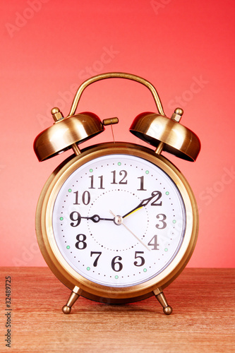Foto: Old alarm-clock on red background Old alarm-clock on red background