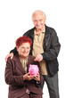 A mature people putting a coin into a piggy bank A mature people putting a coin into a piggy bank