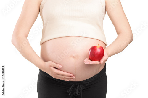 Photo: Pregnant woman holding a red apple Pregnant woman holding a red apple