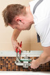 Installateur bringt Mischbatterie im Bad an
