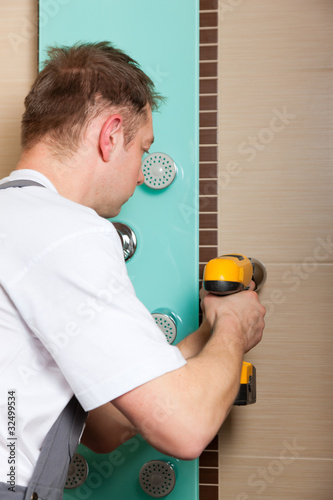 Foto: Installateur bringt Mischbatterie im Bad an Installateur bringt Mischbatterie im Bad an