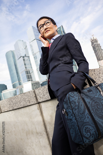 Photo: Businesswoman, skyscraper background Businesswoman, skyscraper background