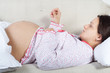 Pregnant woman checking her body temperature Pregnant woman checking her body temperature
