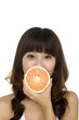 smiling female face with fresh grapefruit in her hands