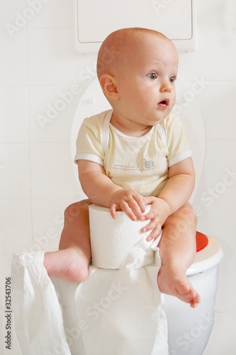Foto: Cute baby sitting on a toilette Cute baby sitting on a toilette