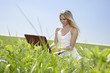 Photo: young woman sitting in grass with notebook young woman sitting in grass with notebook
