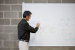 Professor writing formula on whiteboard