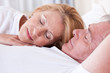 Mature couple sleeping in bed